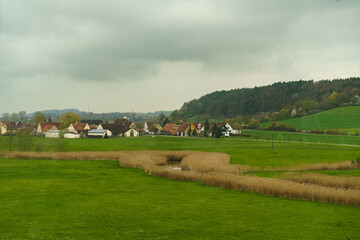 Fototapeta na wymiar There are rain clouds above the German village, next to the village there is a forest, a field and a pond