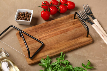 Wooden kitchen board, spices, tomatoes and parsley on color background