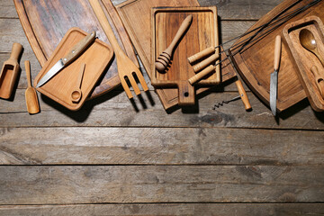 Different cutting boards, knives, skewers and corkscrew on wooden background