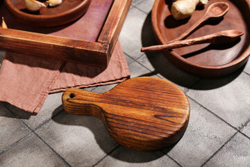 New wooden cutting board on grey tile background