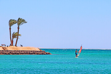 Lonely man on windsurfing board driving on sea during quarantine of coronavirus