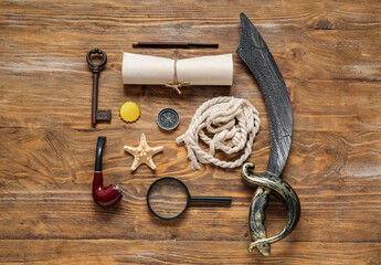 Different pirate equipment on brown wooden background