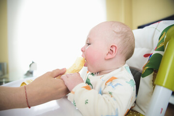 woman giving banana to her baby