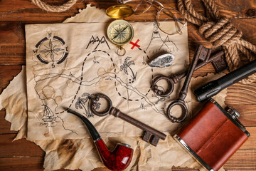 Fototapeta na wymiar Treasure map with travel equipment, hip flask and smoking pipe on brown wooden background