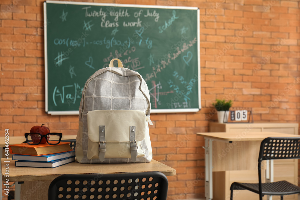 Canvas Prints Stylish school backpack with books, apple and eyeglasses on desk in classroom