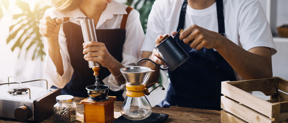 Happy young adult couple making breakfast and drinking coffee together in cozy home kitchen in morning at home. Preparing meal and smiling. Lifestyle, leisure and Love concept.