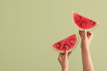Fototapety  Female hands with slices of ripe watermelon on green background