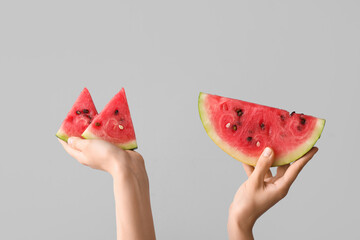 Female hands with slices of ripe watermelon on white background