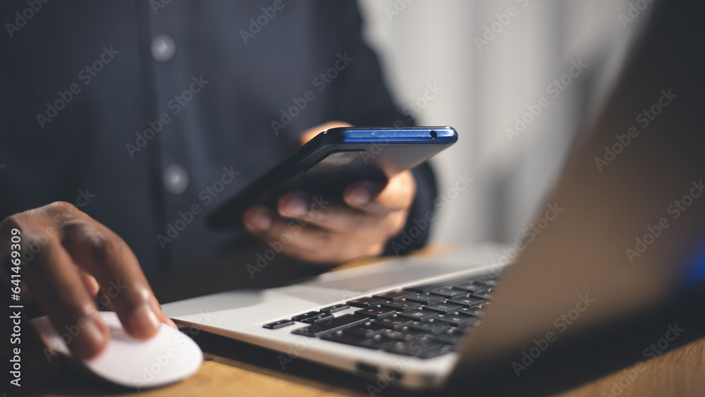 Wall mural hands using a smartphone and laptop simultaneously for secure login, highlighting the importance of 