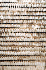 Wooden shingles. Natural roof material of rustic style. Abstract background. Brown and gray color. Old rooftop. Wall facade in village style. Wood pattern. Original surface plank cover