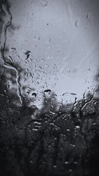 Raindrops on the window. Rain drops close up. Rain falling down on the windshield.