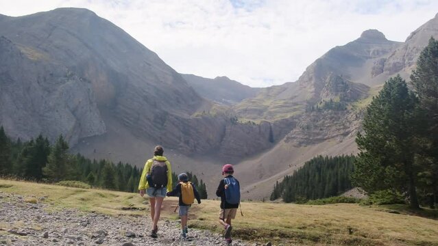 Single mother with two children of 5 and 8 years old walking through the Altas Monta&ntilde;as National Park and lake. A sad day eventura, maternal care, healthy lifestyle, maternal and childhood concept. Ec