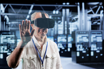 Octogenarian manager immersed in virtual reality at data center, doing equipment maintenance....