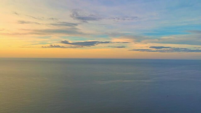 Golden sun rays kiss tranquil waves, painting the sea in hues of orange and pink. The sky awakens with a symphony of colors, as the drone soars, capturing nature's masterpiece at sunrise. 4K.
