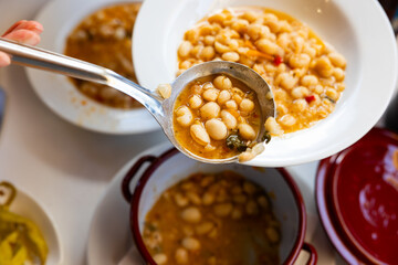 Pochas stewed with vegetables and ham bone in ladle. Aragonese cuisine