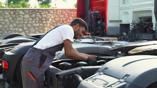 Indian man in uniform repairing a truck. Car malfunction. Truck repair
