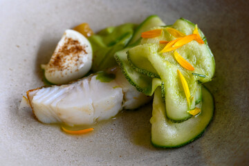 Exquisite white fish and  zucchini dish of modern French haute cuisine prepared with fresh organic ingredients from restaurant own garden and farm and beautifully served