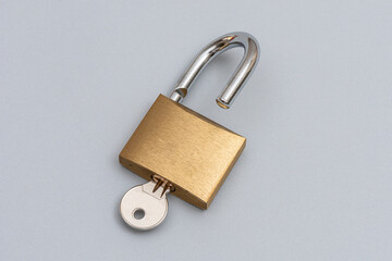 Unlocked golden padlock on the gray background.