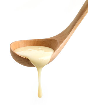 condensed milk in wooden ladle