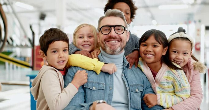 Children, teacher and portrait with a hug in classroom with love in education, learning and kids excited to be in school. Kids, students and support and care for man with a smile on face in class