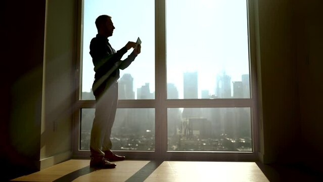 Businessman Starting To Work in Modern Office Opening Window Blinds