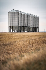 the beautiful symmetry of grain silos in a field © Tristan