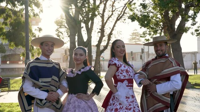 portrait two couples in traditional huaso clothing to dance to the rhythm of the cueca in the square