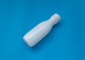 Plastic bottles for dairy products on a colored background. Garbage, used.