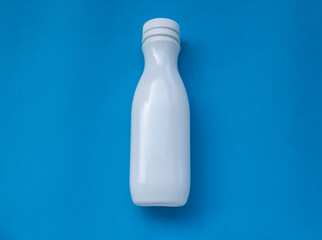 Plastic bottles for dairy products on a colored background. Garbage, used.
