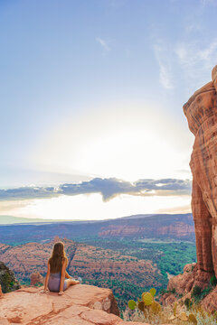 Little girl on the edge of a cliff at Cathedral Rock in Sedona, Arizona. View from Scenic Cathedral Rock in Sedona with blue sky in Arizona