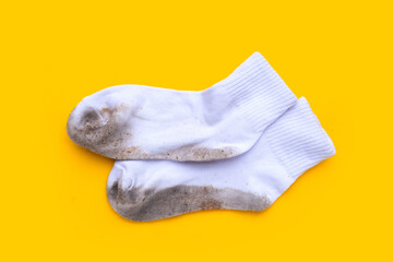 Dirty white socks on yellow background.