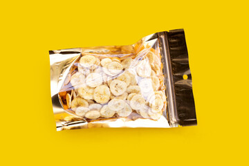 Banana slice chips on yellow background.