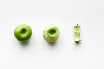 Three stages of apple: just bought ripe green apple, peeled apple and apple core isolated on white background 