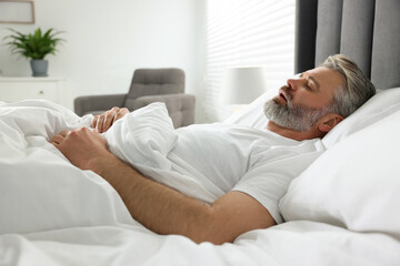 Man snoring while sleeping in bed at home