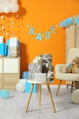 Obraz premium Baby shower party. Festive decor, gift boxes, booties and toys in stylish room