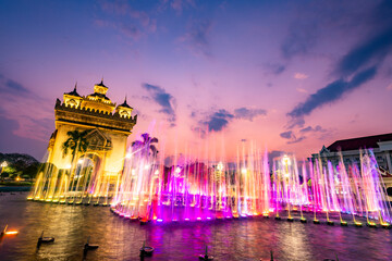 Water fountain and multi colored lightshow, at sunset,next to Patuxai monument in Vientiane, Laos.