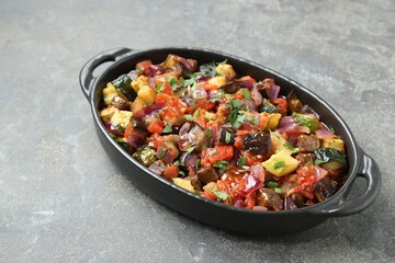 Dish with tasty ratatouille on grey textured table