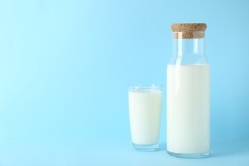 Obraz na płótnie Canvas Carafe and glass of fresh milk on light blue background, space for text
