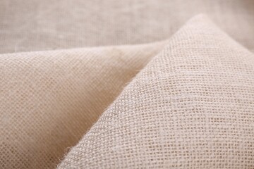 Texture of beige burlap fabric, closeup view
