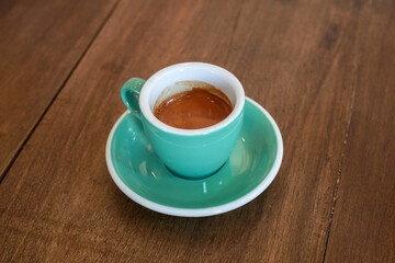 Hot coffee cup on wooden table in cafe morning warm sunlight. Espresso, breakfast. Background with copy space