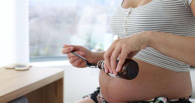 Prenatal supplements during pregnancy. Pregnant woman eating omega 3 vitamin of cod fish oil on 1st, 2nd and 3rd trimester for brain development.
