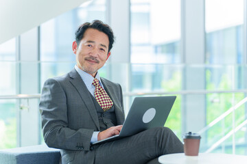 オフィスでパソコンを使うシニアビジネスマンのポートレート