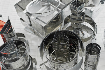 Baking forms of different sizes and shapes hanging in restaurant kitchen, high angle view   
