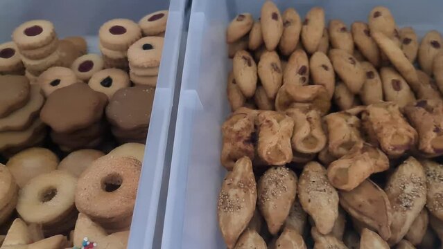 Wide variety of small Mexican cookies inside plastic boxes