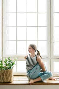 Female yogi on window sill