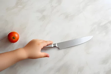 Fotobehang Children and the dangers of knives and sharp objects. Child hand holding paring knife on white marble table Take it to play without knowing how to do it. May cause hand cuts and injuries. copy space. © chawalit