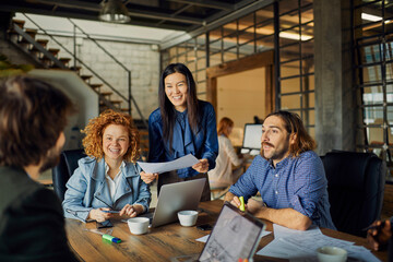 Young and diverse group of coworkers working on a project and having a meeting in a startup company...