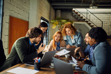 Young and diverse group of coworkers working on a project and having a meeting in a startup company office