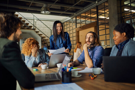 Young And Diverse Group Of Coworkers Working On A Project And Having A Meeting In A Startup Company Office