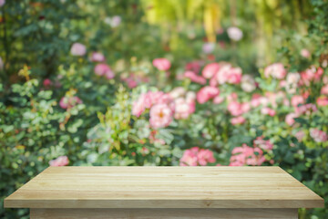 Fototapeta na wymiar Empty wood table top with blur rose garden background for product display